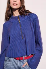 Sweater marrón de punto acanalado, con cuello alto, cierre frontal parcial con cremallera y manga larga.