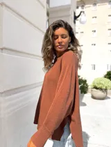 Sweater de punto color moka, con diseño oversize, cuello redondo, costura central vertical y puños acanalados.