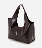 Cartera shopper grande Satinato confeccionada en PU color bordó con acabado efecto charol, diseño amplio de trapecio invertido, asas amplias para el hombro y cierre magnético.