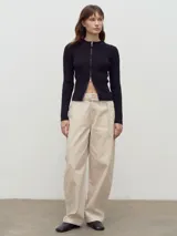 Cardigan de punto acanalado color negro, con cuello redondo y cierre frontal doble que permite abrirlo desde arriba o desde abajo.