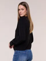 Blusa negra de rayón con textura smock en la pechera, escote en V con cuello mao fruncido, mangas largas fluidas con puños anchos y detalle de volados en el ruedo.