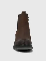 Bota tipo Chelsea de cuero marrón con paneles laterales elásticos en color negro. Presenta costuras reforzadas en el contorno y una suela robusta de poliuretano con base dentada en tono gris translúcido.
