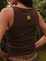 Top de punto acanalado, con diseño ajustado que realza la silueta. Presenta bordados en la parte delantera y trasera, aportando un toque distintivo.
