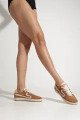 Zapatillas Schutz color camel, de gamuza, con cordones blancos y detalle de cuero con pelo en el talón.