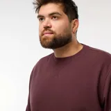 Sweater de punto canalé color borgoña, con cuello redondo y mangas largas.