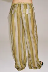 Pantalón ZARA Woman Collection confeccionado en mezcla de lyocell, con diseño de rayas verticales en tonos verde oliva y beige. Presenta tiro medio, cintura ajustable con cordón y perneras rectas.