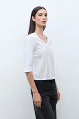 Remera de manga tres cuartos con escote en V, confeccionada en tela con textura de broderie en el frente.