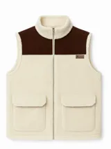 Chaleco color crudo con parte superior en pana marrón, cierre frontal con cremallera, cuello alto y dos bolsillos delanteros.