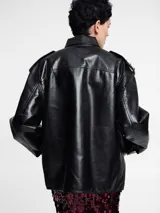 Chaqueta bomber negra de piel sintética con cierre frontal y cuello clásico.