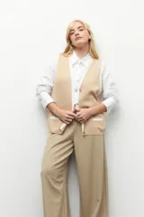 Pantalón sastrero ancho color verde oliva, de tiro alto, con pretina ancha de un botón, bolsillos laterales y pinzas en el frente.