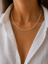 Gargantilla de cuentas de cristal transparente con cadena de alargue dorada y dije de corazón pequeño.
