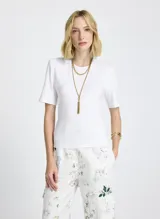 Remera blanca de tejido de punto, corte recto, cuello redondo, manga corta y cierre de lazo en la espalda.