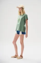 Remera verde militar de algodón, corte holgado, con estampa de dos sardinas y texto "Les Sardines" en el frente.