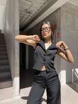 Chaleco negro de tela barbie con corte sastrero y calce al cuerpo.