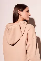 Hoodie color beige de algodón con cordones ajustables en el cuello.