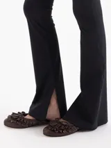 Pantalón Margot de microfibra negra, de tiro alto y silueta ajustada con botamangas acampanadas y tajos laterales.