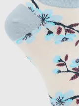 Calcetín corto de algodón con estampado floral en tonos celestes y bordó sobre base color crema. Presenta borde superior con terminación ondulada y puntera y talón reforzados en color celeste.