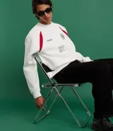 Saco deportivo boxy de algodón felpa color blanco, con cuello redondo, manga raglán larga y recortes rojos en los hombros. Presenta bordados frontales con texto "OFFICIAL NATIONAL MAJOR HARMONY", un logo circular y el número "31". Las mangas tienen un patrón de cuadros rojos y blancos.