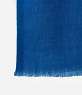 Pañuelo de poliéster color azul, con diseño liso y terminaciones de mini flecos en los extremos.