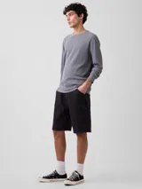 Bermuda de jean estilo carpenter color negro desgastado, de corte holgado, con bolsillos laterales utilitarios y presillas para martillo.
