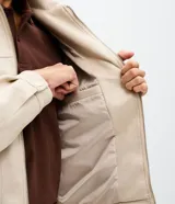 Campera estilo Harrington de corte bomber, confeccionada en material con acabado de gamuza sintética. Presenta cuello con solapa, cierre frontal completo, mangas largas y bolsillos laterales con cierre.