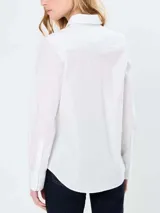 Camisa blanca de manga larga Tommy Hilfiger, de corte regular, con cuello abotonado, cierre con botones y logo bordado en el pecho.