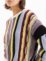 Sweater de tejido semi pesado en mezcla de algodón y lana, de calce oversize y hombros caídos, con cuello redondo y mangas largas. Destaca por su diseño jacquard multicolor con patrones texturizados y rayas verticales.