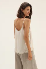 Musculosa color blanco con breteles finos y ruedo desflecado.