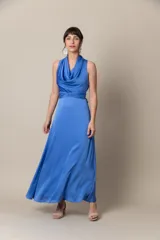 Vestido largo de seda color azul, con cuello drapeado y cintura ajustada con lazo.