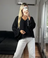 Blusa de tela cey color bordó, con escote en V y mangas largas abullonadas que terminan en puños con detalle de encaje y volados.