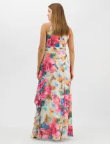 Vestido largo de chifón con estampado floral multicolor. Presenta cuello halter con plisado en el pecho, cintura drapeada y falda amplia con capas asimétricas que aportan movimiento. Incluye forro interior y cierre invisible en la espalda.