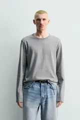 Camiseta de manga larga color gris jaspeado, corte regular fit y cuello redondo con acabado en rib.