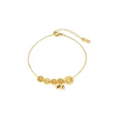 Tobillera dorada con cadena fina y dijes colgantes de monedas chinas caladas y bolitas lisas.