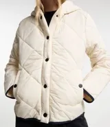 Campera de microfibra ligera color crudo, con textura capitoneada, capucha, cierre con botones a presión, mangas largas y puños con ribete en contraste.