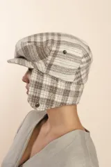 Boina con visera y orejeras de lana color beige con diseño de espiga.