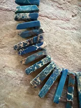 Collar corto elaborado con piezas rectangulares de jaspe imperial en tonos azul petróleo, con vetas blancas y marrones.