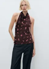 Top halter marrón con estampado de rosas rosadas, espalda descubierta y cierre de lazo en el cuello. Diseño entallado.