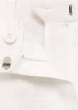 Pantalón de lino color blanco, con tiro medio, diseño de pernera recta y cierre frontal con botón, gancho y cremallera ocultos.