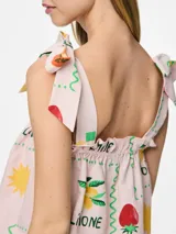 Top corto sin mangas con cuello cuadrado y tirantes ajustables con lazo. Presenta un estampado de frutas (fresas, limones/naranjas) y un patrón de cuadros en tonos verde, amarillo y rosa pálido. El borde del escote y el ruedo tienen un ribete ondulado verde.