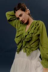 Camisa verde de manga larga, con volados frontales y detalles de puntilla bordada.
