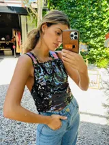 Top corto negro con lentejuelas plateadas y tirantes anchos color rosa.