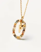 Collar dorado con dije ovalado con incrustaciones de piedras de colores y letra P dorada en el centro. Cadena de eslabones dorada.