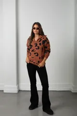 Buzo de tejido de punto con estampado animal print, cuello alto con cierre frontal y mangas largas.