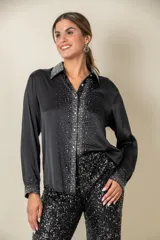 Camisa color crema de satén italiano con cuello clásico, cierre frontal con botones y mangas largas. Presenta apliques de strass en cuello, solapa y puños.