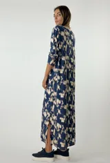 Vestido largo color lila con estampado abstracto en blanco, cuello en V con lurex y mangas largas.