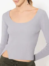 Top negro de tejido de punto fino, con escote redondo y mangas largas.