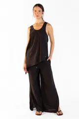 Pantalón ancho negro con bolsillos laterales, pretina elástica y cortes en los laterales que aportan movimiento. Confeccionado en mezcla de tencel y nylon.
