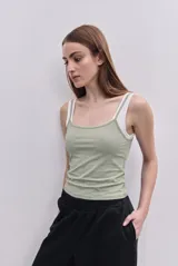 Musculosa de calce al cuerpo, confeccionada en tejido elastizado color verde menta, con escote recto, breteles finos y detalle de breteles anchos en contraste de color blanco que genera un efecto superpuesto.