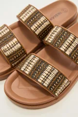 Sandalia tipo slide de color marrón, con doble tira ancha tejida en tonos tierra y negro, y suela anatómica de goma.