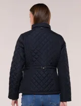Campera capitoneada negra con costuras multidireccionales, cuello alto, cierre frontal y bolsillos laterales con cierre.